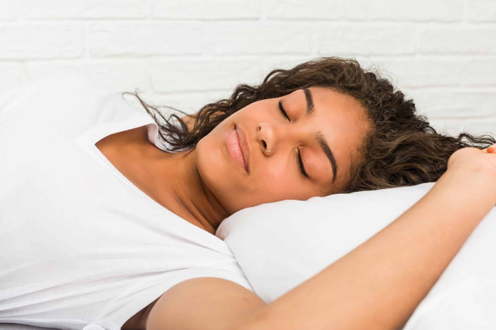 Close up of a young african american tired woman sleeping on the bed
